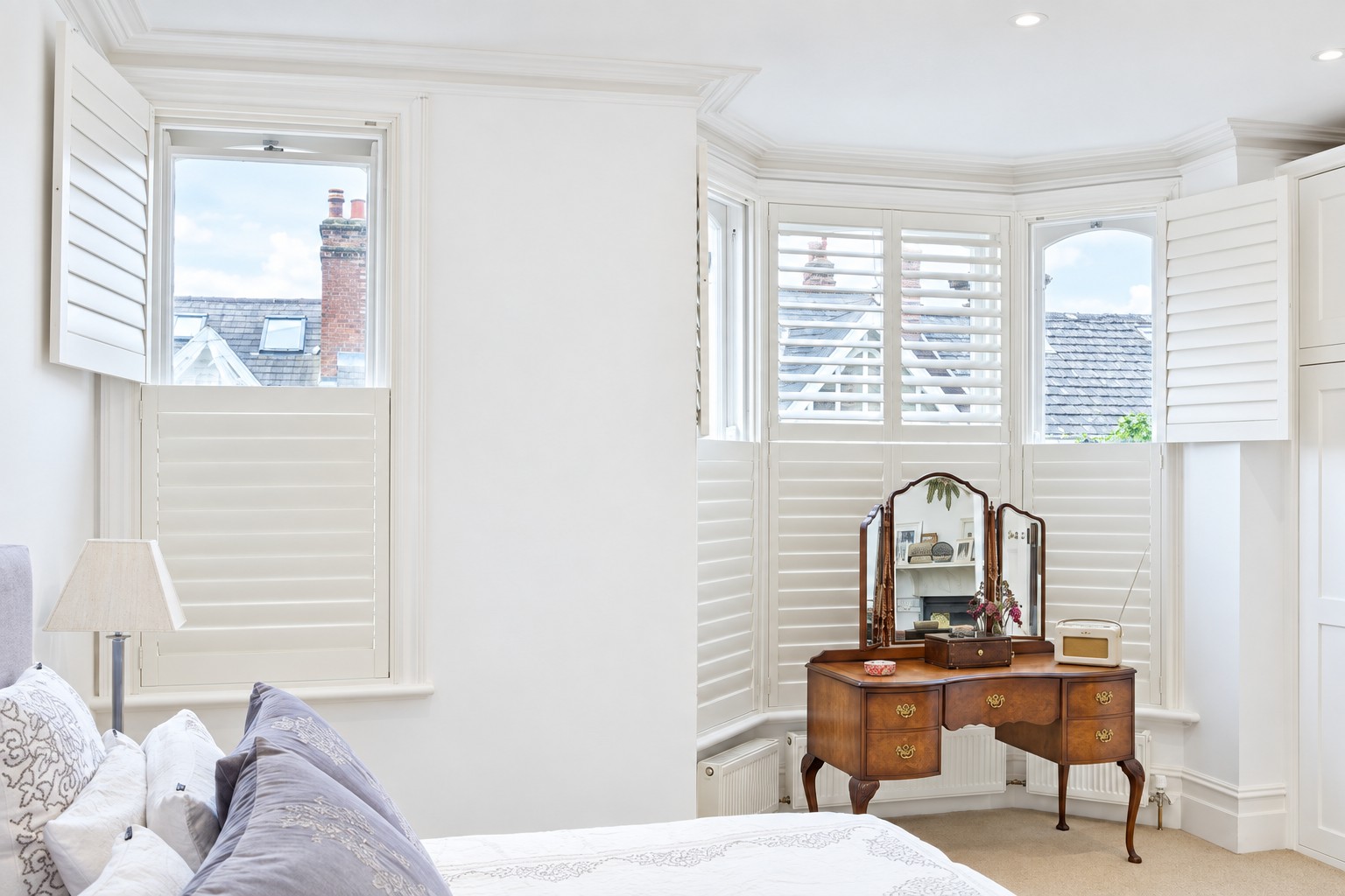 Tier-on-tier shutters fitted inside the recess of a bedroom bay window