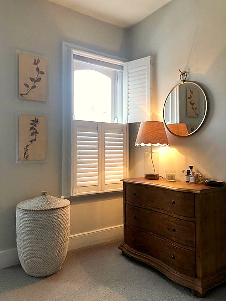 bedroom with half open tier on tier shutters