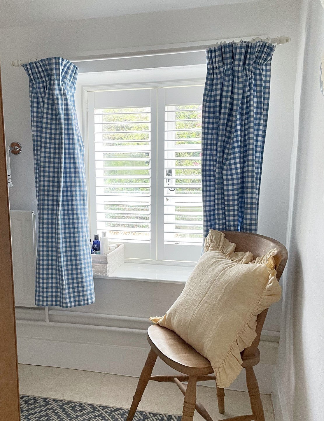Window with blue curtains and a white full-height shutter