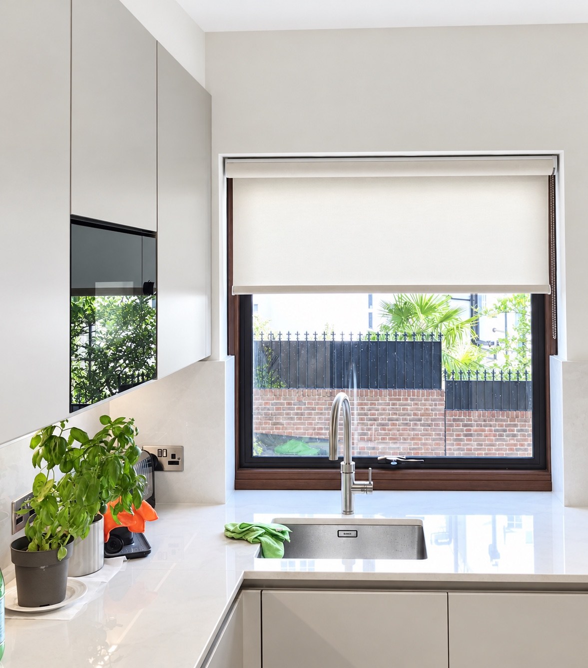 White roller blind fitted to a kitchen window above the sink