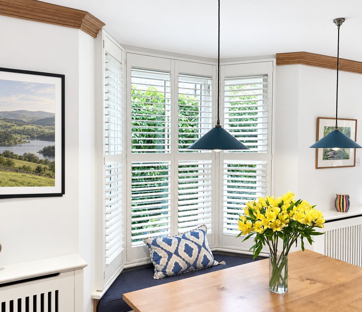 White full-height shutters fitted to a kitchen bay window in Battersea with a window seat