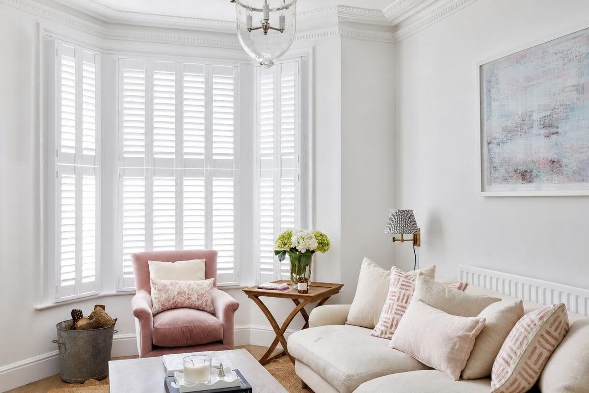 Tier-on-Tier shutters fitted to a bay window in a bright living room
