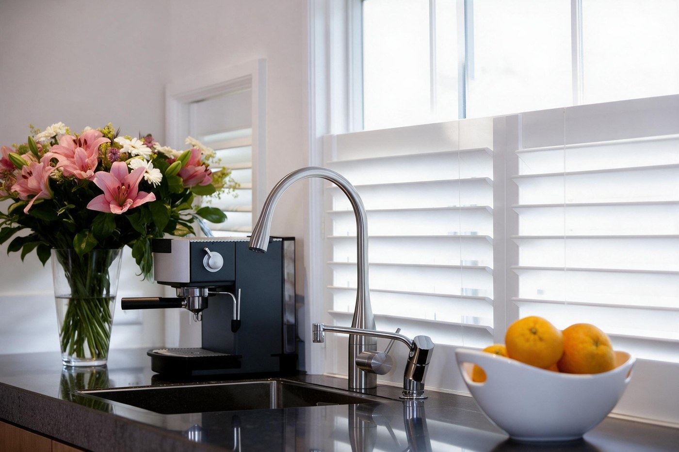 Café style shutters above a kitchen worktop with fresh flowers and an espresso machine