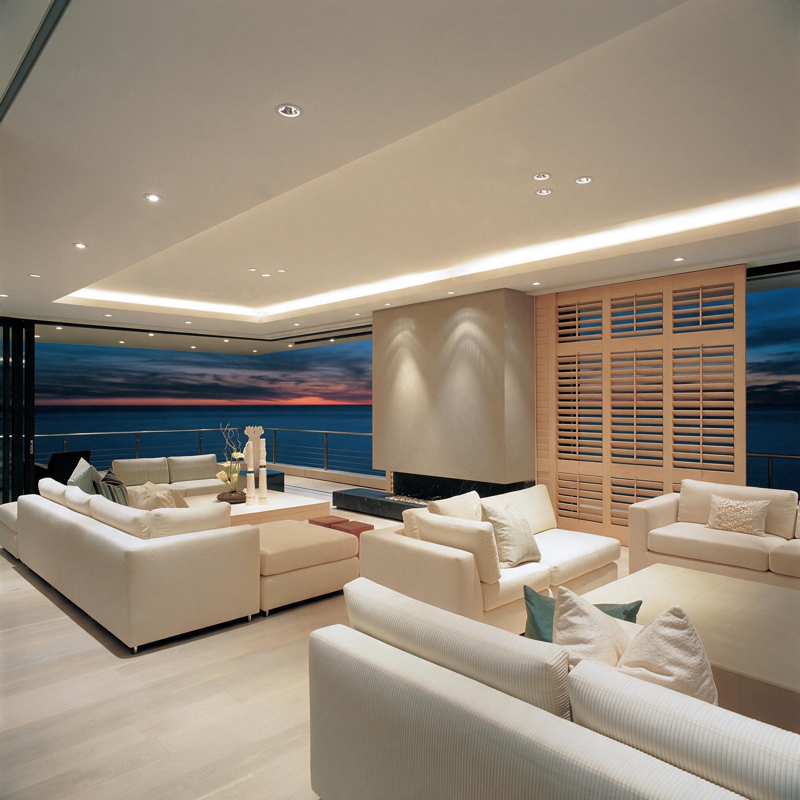 Wooden sliding shutters in a contemporary lounge overlooking the sea
