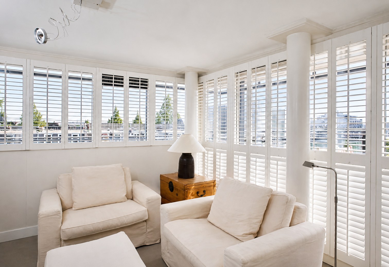 White shutters around a bright living room with seating