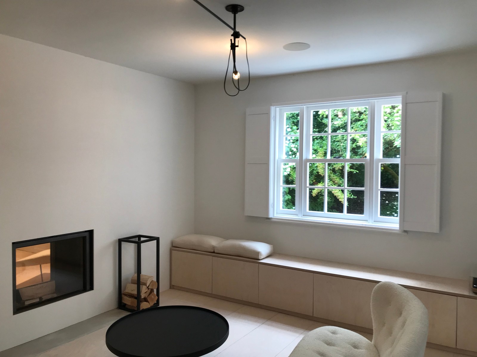 Solid Shaker shutters fitted to a wide window in a contemporary living room