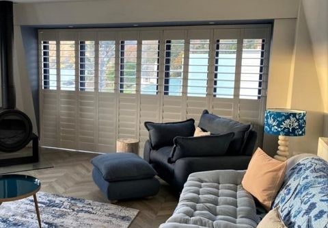 Sliding shutters fitted across a wide glazed opening