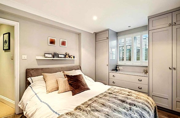 small bedroom with wardrobe built around the window with full height shutters that gives privacy