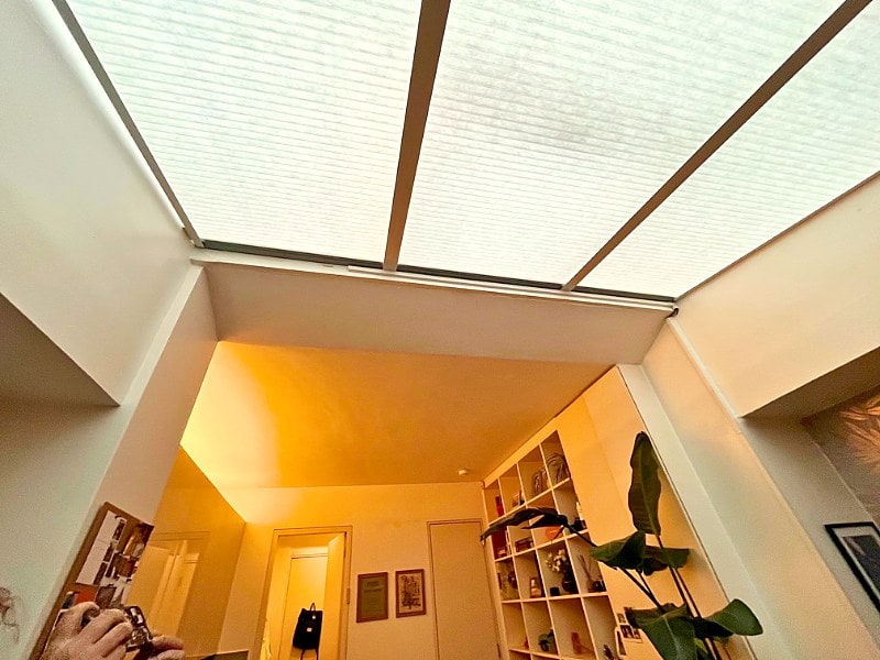 Motorised honeycomb blinds fitted to a large skylight window in a contemporary living room in Ladbroke Grove, West London