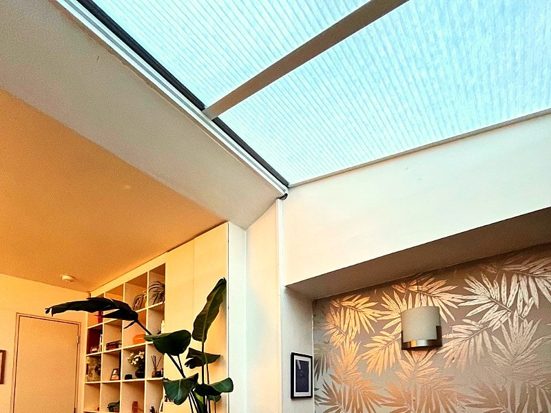 Details of a motorised honeycomb blind installation on a skylight window in a modern house in Ladbroke Grove, West London