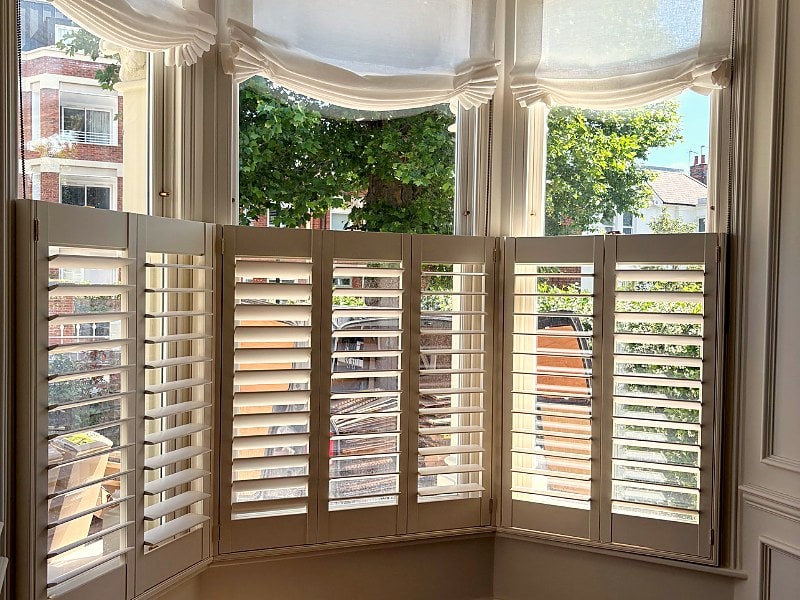 Café style plantation shutters fitted to a Victorian bay window in Ealing