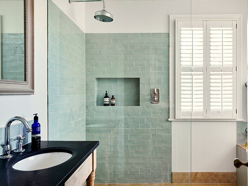 bathroom with shower and shutters on the window