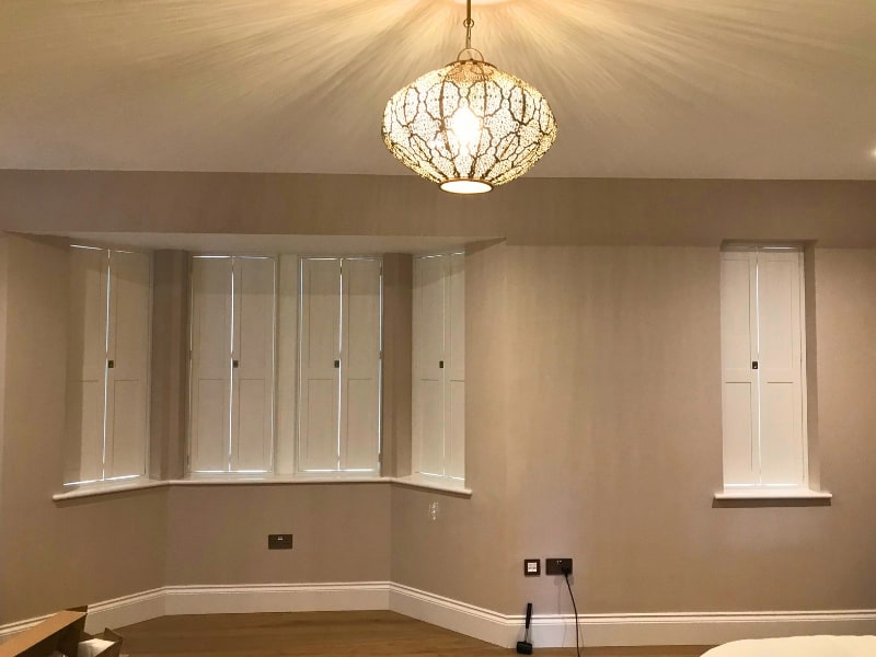 Solid Shaker shutters installed across a bay window in Thames Ditton, Surrey
