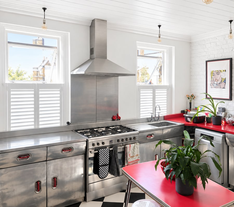 Café style shutters in a kitchen with a red worktop