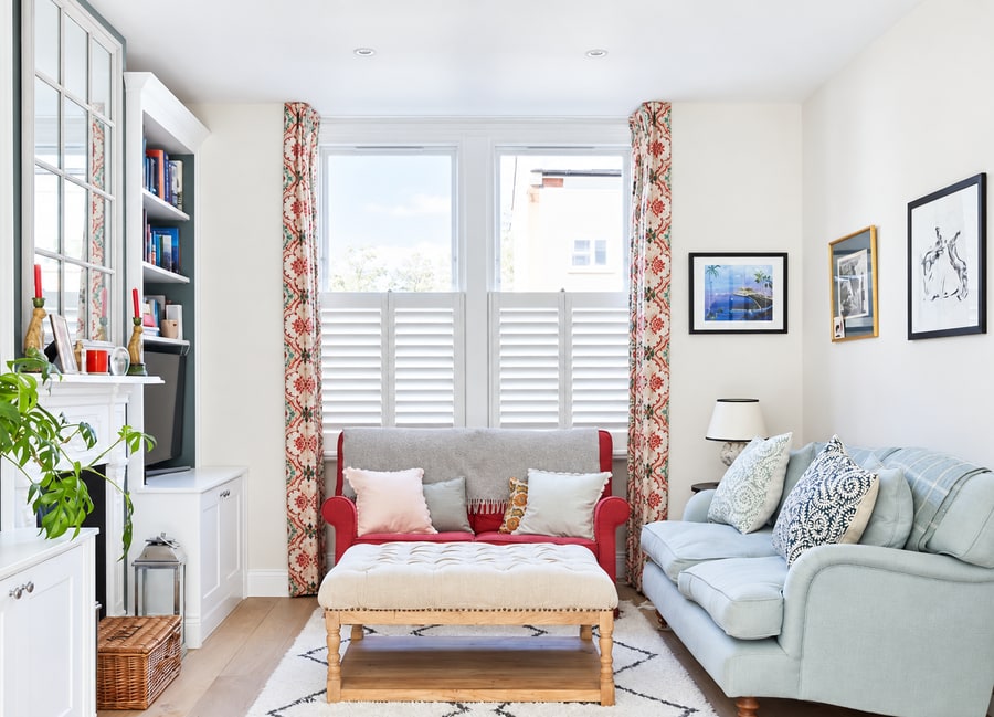 Café style shutters in a lounge with a red sofa