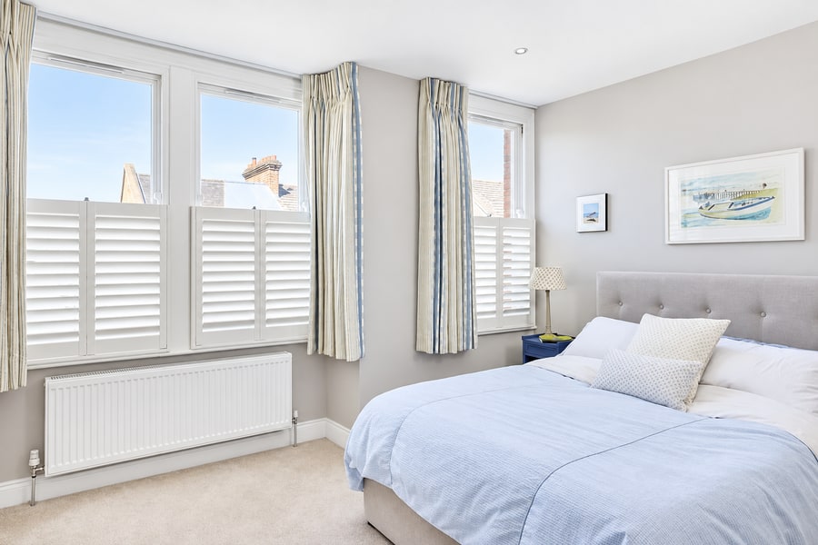 Café style shutters in a bright bedroom