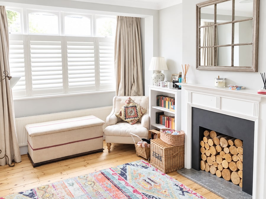 Café style shutters in a living room with a log fireplace