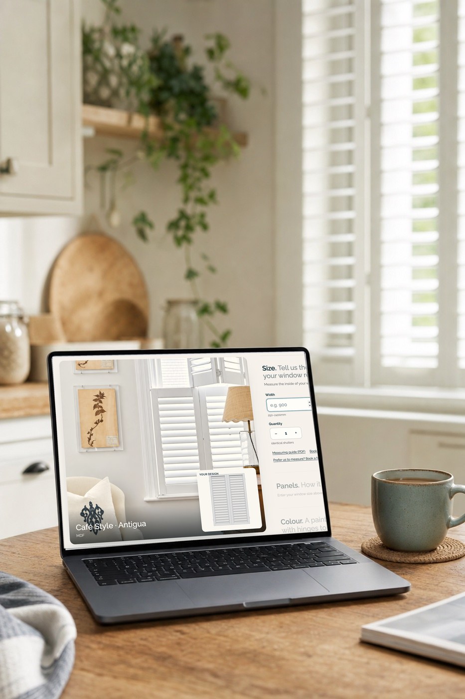 Laptop showing the online shutter designer beside a window with white shutters